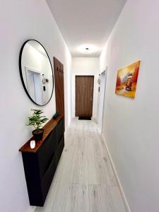 pasillo con espejo, tocador y puerta en Cozy flat, en Sibiu