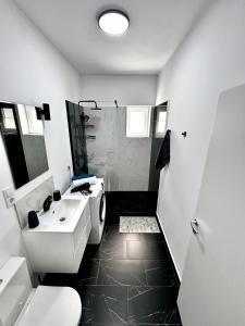 Un baño blanco con lavabo y ducha. en Cozy flat, en Sibiu