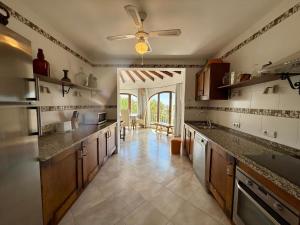 a large kitchen with wooden cabinets and a ceiling fan at AT060 Villa Ortenbach in Ifach