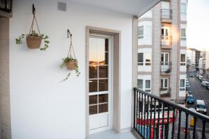 a balcony with two potted plants and a door at Ideal Turismo Ribeira Sacra in Chantada