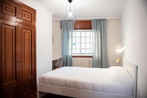 a bedroom with a white bed and a window at Ideal Turismo Ribeira Sacra in Chantada