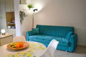 a living room with a blue couch and a table with fruit at Residenz Lagobello in Germignaga