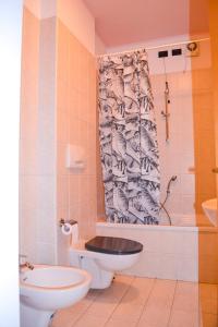 Un baño con inodoro, lavabo y ducha. en Residenz Lagobello, en Germignaga
