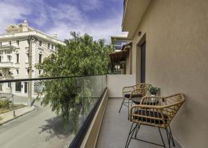 a balcony with two chairs and a tree at D'Oliva, by ZanteWize in Zakynthos Town