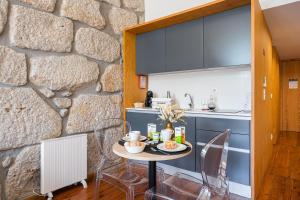 ポルトにあるGuestReady - Porto de Rio Residencesの石壁のキッチン(小さなテーブル付)