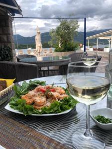 a plate of food on a table with a glass of wine at Aquamarine House in Tivat