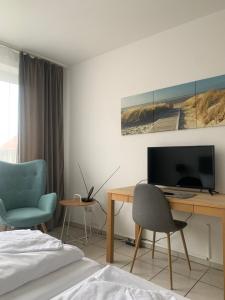 a bedroom with a desk with a computer and two chairs at Hotel Calenberger Hof in Wennigsen