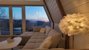 a living room with a couch in front of a large window at Air Cabin, Cabana tip A-frame in Șerani, Bihor in Şerani