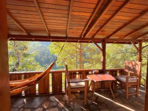a porch with a hammock and a table and chairs at Friendly Homestay Lemukih in Singaraja