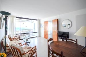 a living room with a table and a couch at Chez Alain - Confortable appartement et vue à couper le souffle in La Grande-Motte