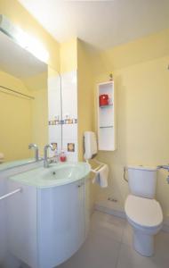 a bathroom with a white toilet and a sink at Chez Alain - Confortable appartement et vue à couper le souffle in La Grande-Motte