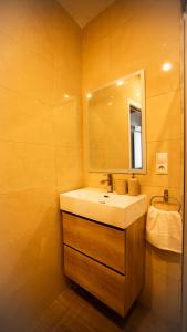 une salle de bain avec un lavabo blanc et un miroir dans l'établissement Apartamento Caballero Home, à Séville