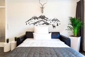 een slaapkamer met een bed met bergen aan de muur bij Relax Apartment Black & White in Friedrichshafen