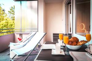 een tafel met een kom eten en een glas sinaasappelsap bij Relax Apartment Black & White in Friedrichshafen