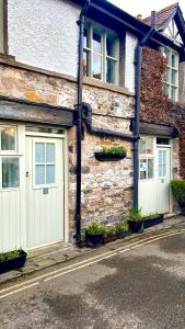 a stone building with two garage doors on a street at Kings Arms Hotel in Kirkby Lonsdale