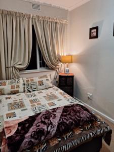 En eller flere senge i et værelse på Constantia Garden Cottage