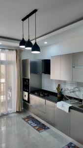 a kitchen with white cabinets and black counter tops at Romi Homes in Mombasa
