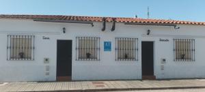 a white building with barred windows on it at Bungalows Sierra San Benito in Cala