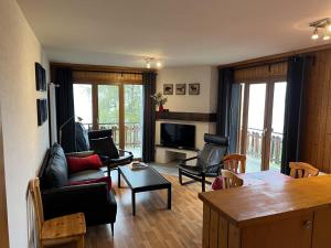 a living room with chairs and a couch and a television at Melezes K 010 - SKI & NATURE apartment 6 pers in Veysonnaz