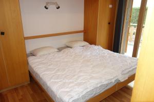 a bed in a room with a white bedsheet at Melezes K 010 - SKI & NATURE apartment 6 pers in Veysonnaz