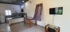 Una cocina con una mesa y un televisor en la pared. en VILLA RISHAAM with swimming pool, en Pondicherry