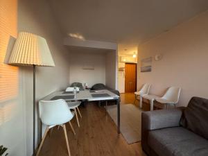 Una sala de estar con un sofá, una mesa y sillas. en Kotimaailma-Studio Keskustassa, en Kokkola