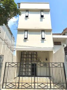 a white building with a gate in front of it at Helloroom Mampang Jl Bank in Jakarta