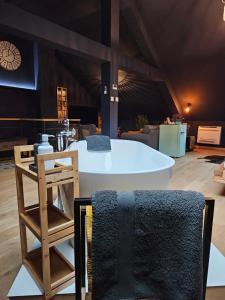 a bath tub in a room with a table and chairs at Le Duché de Godefroy in Bouillon