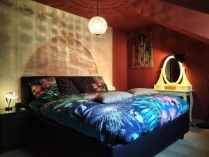a bedroom with a bed with a colorful comforter at Le Duché de Godefroy in Bouillon