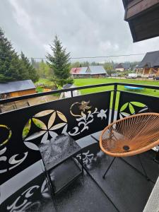 Un patio con una silla y una pared con grafitis. en Apartament Parzenica przy Termach Chochołowskich, en Witów