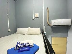 a hospital room with a bed with a karma burger sign on it at Helloroom Mampang Jl Bank in Jakarta