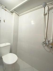 a white bathroom with a toilet and a shower at Helloroom Mampang Jl Bank in Jakarta