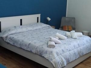 un letto con lenzuola bianche e cuscini sopra di A UN PASSO DAL DUOMO " con GARAGE AUTO GRATUITO" a Catania