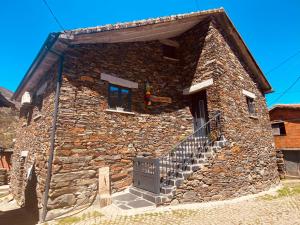 a stone building with a door and stairs on it at Casa do Avô Zé in Covas do Monte
