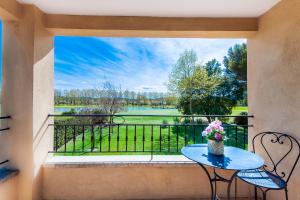 a table and chairs on a balcony with a view at Villa-Provence-Pont-Royal in Mallemort