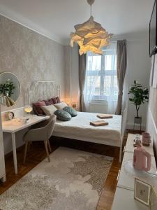 a bedroom with a bed and a table and a desk at Dobry Adres in Gdynia