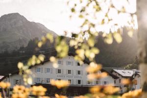un edificio bianco di fronte a una montagna di Après Post Hotel a Stuben am Arlberg