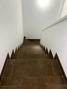 a staircase in a room with white walls and a tile floor at Cornisa Apartments in Patalavaca