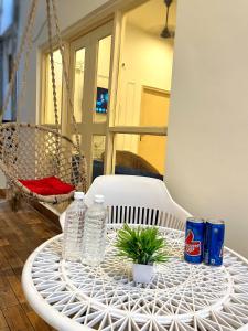 a white rattan table with water bottles and a plant on it at Golden Lotus Varanasi in Varanasi