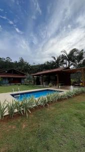 a swimming pool in front of a house at Chácara cantinho na roça, Domingos Martins - Espirito Santo in Domingos Martins