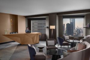 a woman sitting at a desk in a hotel lobby at ANA InterContinental Tokyo by IHG in Tokyo