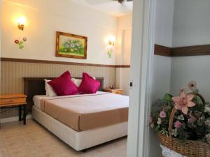 a bedroom with a bed with pink pillows at Berjaya hill meranti park in Bentong
