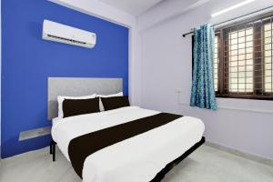 a bedroom with a large bed with a blue wall at Hotel O Green leaf inn in Surūrnagar