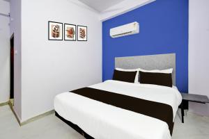 a bedroom with a large bed with a blue wall at Hotel O Green leaf inn in Surūrnagar