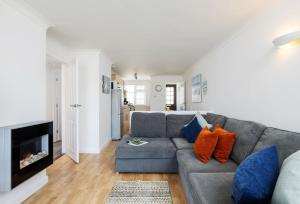a living room with a gray couch and a fireplace at 3 Europa Court in Mawgan Porth in Mawgan Porth