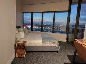 a bedroom with a bed and large windows at 'The Australia St-ar' 2x King beds in Sydney