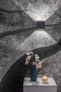 een vaas met bloemen op een tafel met een kaars bij Guest House Colosseo Terrestre in Rome +45 foto's