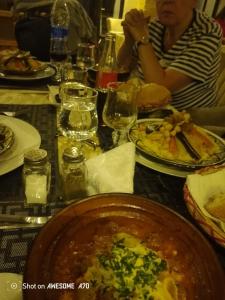 a woman sitting at a table with a plate of food at Gîte du lac chez bennouri in Telouet