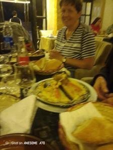 a woman sitting at a table with a plate of food at Gîte du lac chez bennouri in Telouet