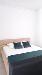 a bed with blue and white pillows on it at Lovely Sunrise in Căţelu